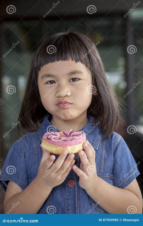 Cara Asiática De La Felicidad De Los Niños Con El Caramelo Dulce A Disposición Foto De Archivo