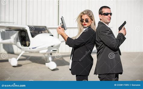 Professional Female And Male Security Spy Agents Posing With Guns Stock