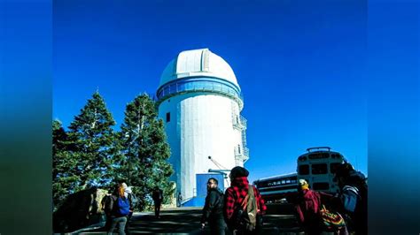 Three People Are Standing In Front Of A Very Large White Structure With