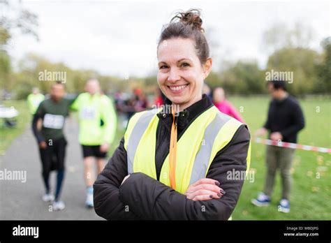 Portrait Smiling Female Volunteer At Charity Run In Park Stock Photo