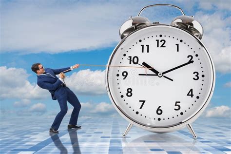 The Businessman Pulling Clock In Time Management Concept Stock Image