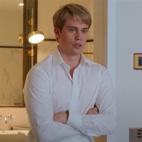 A Man Standing In Front Of A Bathroom Mirror With His Arms Crossed And