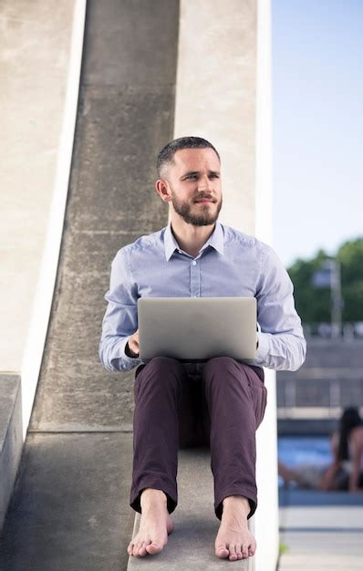 Premium Photo | Barefoot businessman using laptop outdoors