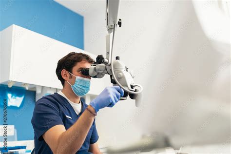 Dentist during a dental intervention using microscope. Stock Photo ...