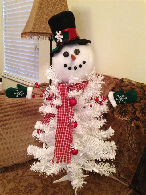 A White Christmas Tree With A Snowman On Top