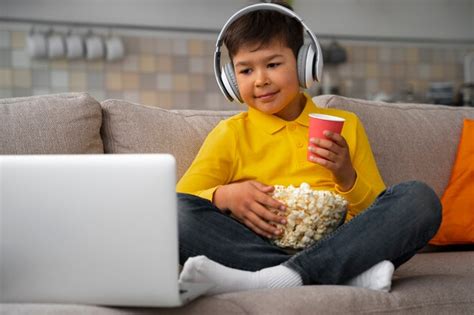 Niño Viendo Películas En La Computadora Portátil Foto Gratis