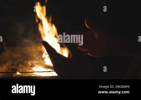 Male Tourist Warms His Arms By A Fire From Metal Brazier Against The