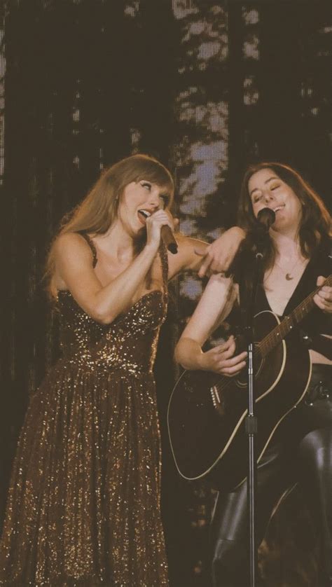 Two Women Singing Into Microphones While Holding Guitars