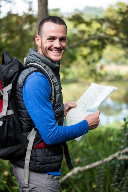 Alpinista Masculina Segurando Um Mapa Na Floresta Foto Premium