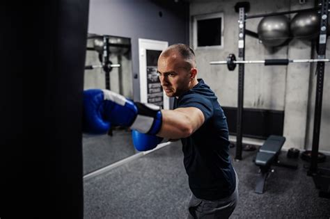 Homem Usando Luvas E Batendo Em Um Saco De Boxe Preto Em Uma Academia