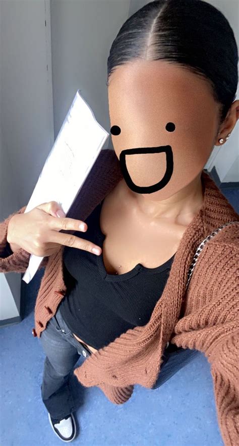 A Woman Wearing A Face Mask Holding A Piece Of Paper In Front Of Her Face