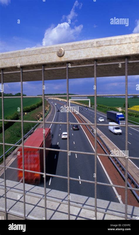 Looking Down On Traffic Through Protective Fence On Bridge Crossing The