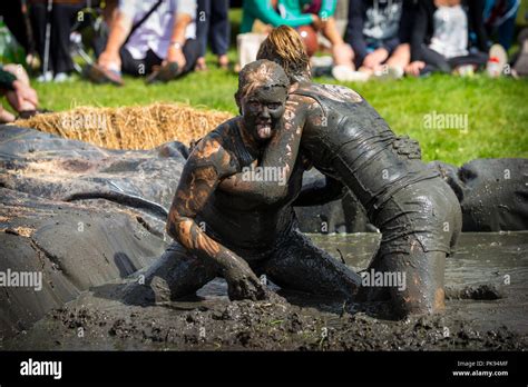 Two women mud wrestling at a mud fighting competition at The LowLand Games in Thorney Somerset ...