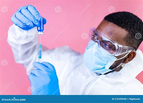 African American Man Scientist In Ppe Suite Uniform Showing Medicine