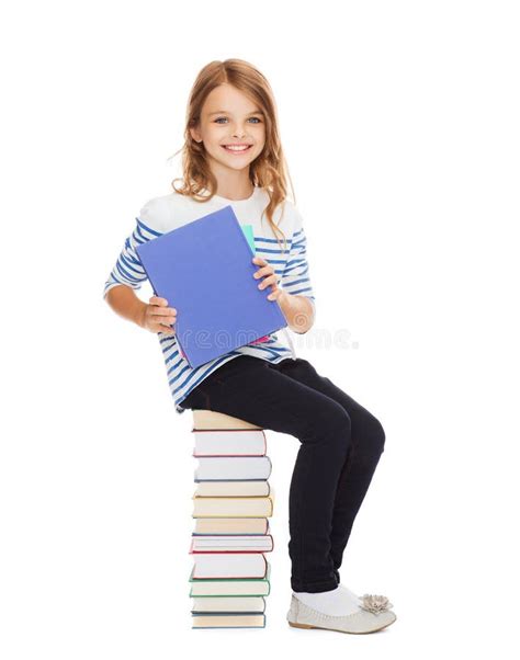 Menina Pequena Do Estudante Que Senta Se Na Pilha De Livros Foto De