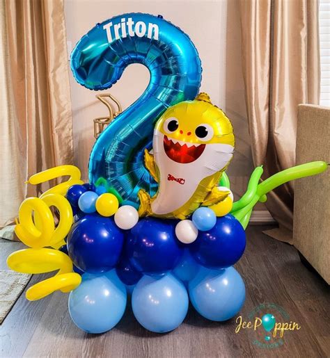 A Balloon Shaped Like A Shark On Top Of Some Blue And Yellow Balloons