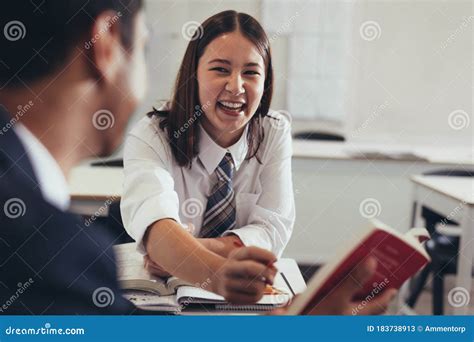 Two Students Talking and Smiling in Classroom Stock Image - Image of talking, happy: 183738913