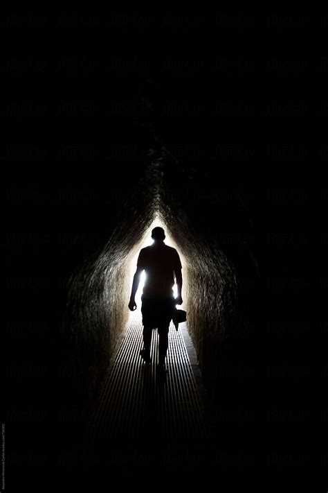 "Silhouette Of A Man Walking Through An Underground Tunnel" by Stocksy