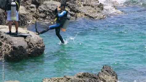 Slow Motion Of Scuba Diver Jumping In The Water From Rock Of Coast