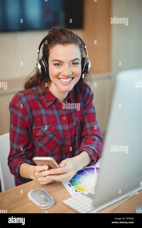 Female Graphic Designer Using Mobile Phone In Office Stock Photo Alamy