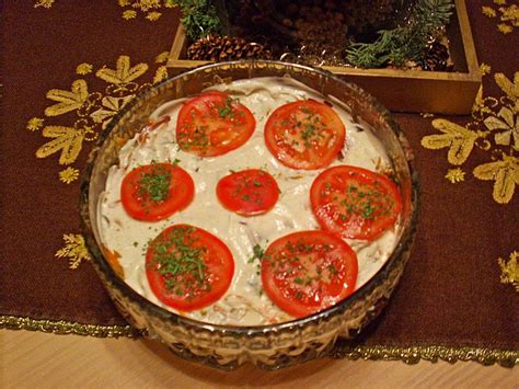 A Dish With Tomatoes And Cream Cheese In It Sitting On A Table Next To