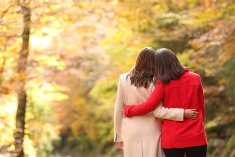 Couple Of Lesbian Women Walking In Autumn In A Forest Stock Photo