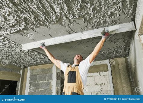 Plasterer Smoothing Plaster Mortar On Ceiling With Screeder Stock Photo