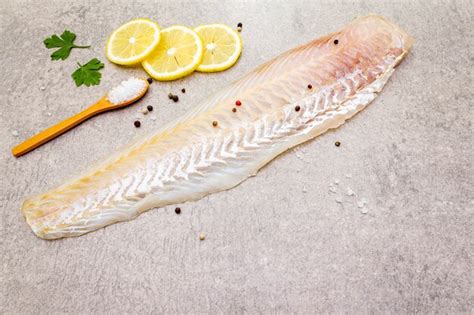 Premium Photo | Fresh raw hake fillet with lemon, parsley and salt