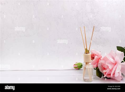 Air Freshener Sticks On White Wood Background With Pink Roses Copy