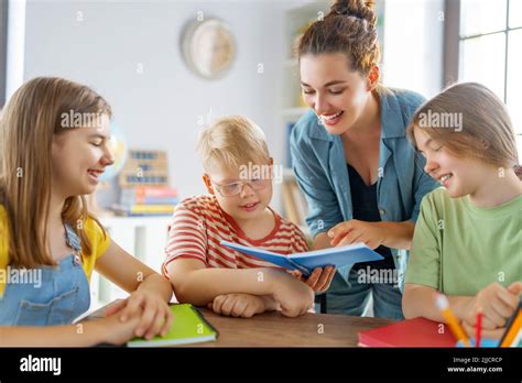 Enfants Heureux Et Enseignant à L école Les Femmes Et Les Enfants Parlent En Classe Photo Stock