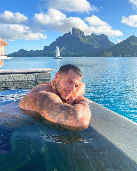 A Man Laying On Top Of A Swimming Pool Next To A Large Body Of Water