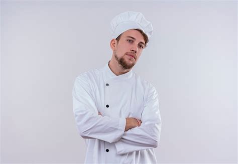 Um Jovem Chef Barbudo E Confiante Vestindo Uniforme Branco De Fog O E