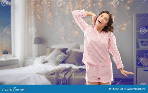 Mujer En El Pijama Que Estira Sobre Dormitorio De La Noche Foto De