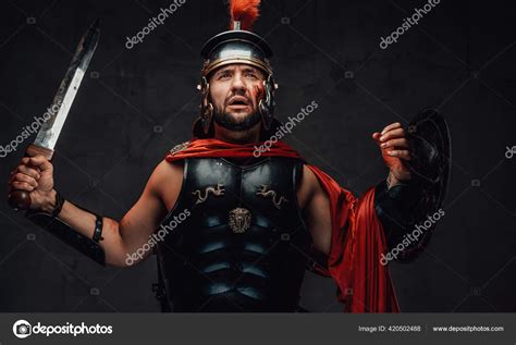 Roman Champion With Armour And Red Cloak In Dark Background Stock Photo