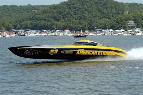 A Yellow And Black Speed Boat Speeding Across The Water With Other