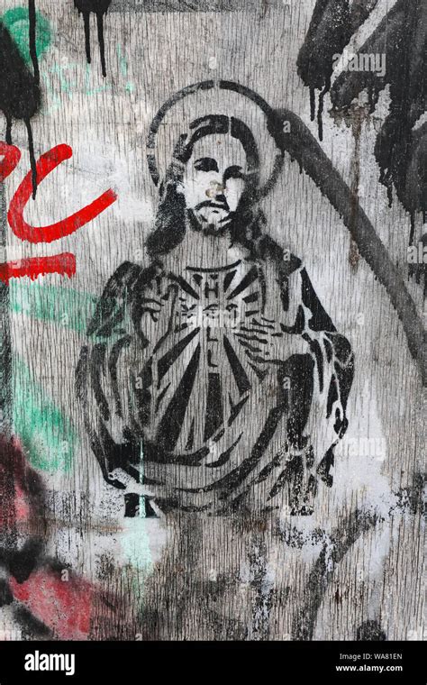 Stencil graffiti of Jesus Christ on a weatherworn plywood box in ...