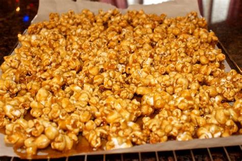 a tray filled with caramel popcorn sitting on top of a counter next to an oven