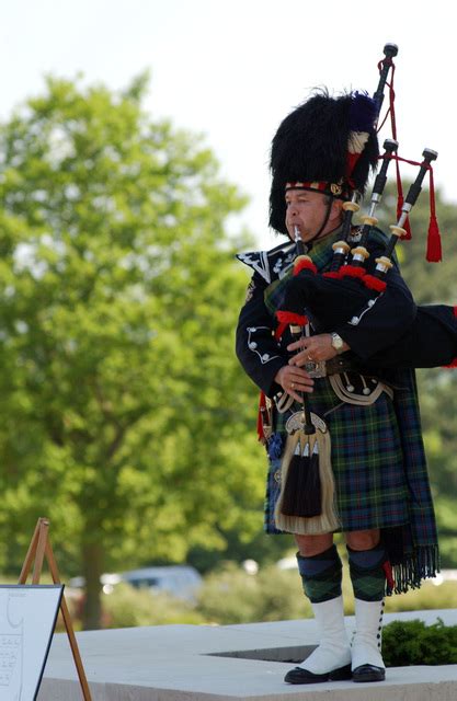 British Bagpiper Gary Kernaghan Plays During The Memorial Day Ceremony