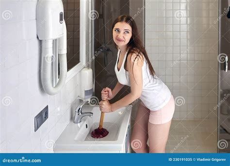 Woman Cleaning Bathroom Sink Drain Using Plunger Stock Image Image