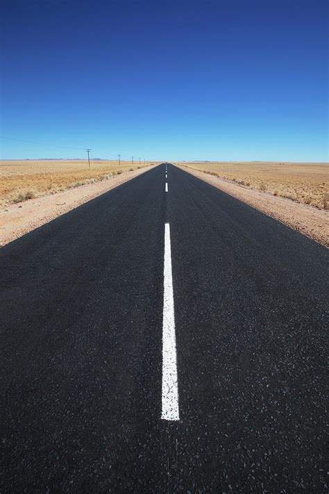 White Line On A Paved Road In The Desert by Lars Froelich / Design Pics