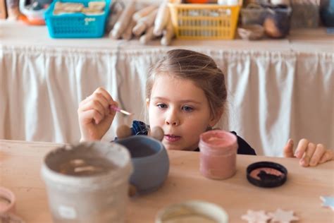 Taller de alfarería para niños niña trabajando con arcilla Foto Premium