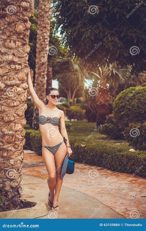 Femme Dans Le Bikini Sous La Paume Sur Le Fond De Jardin Photo Stock