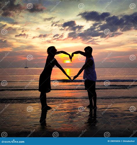 Young Couple Holding Hands Heart-shaped At Sunset Royalty Free Stock ...