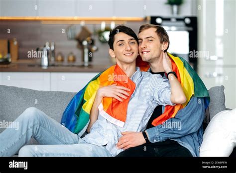 Two Homosexual Guys In Love Spend Time Together On The Couch In The Living Room Gay Couple