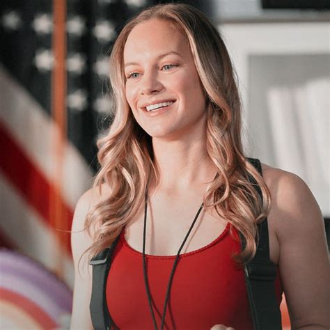 A Woman In A Red Top Is Smiling And Listening To Music On Her Headphones