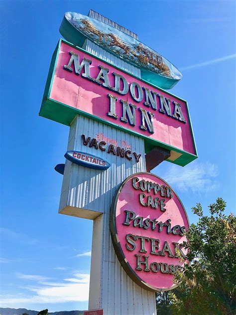 The Sign For Madonna Inn Is Pink And Green