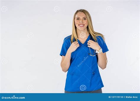 Hot Blonde Nurse Performing Her Duites Against A White Background In A