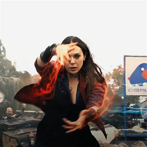 A Woman Is Dancing In The Middle Of A Fire Filled Area With Other