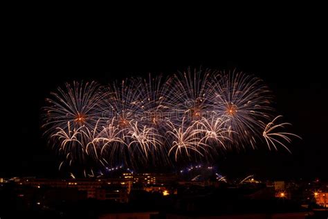 Fuegos Artificiales De Lilas Y Naranjas En Un Cielo Nocturno Imagen De