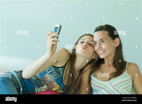 Young Woman Photographing Self With Friend Holding Up Cell Phone Stock